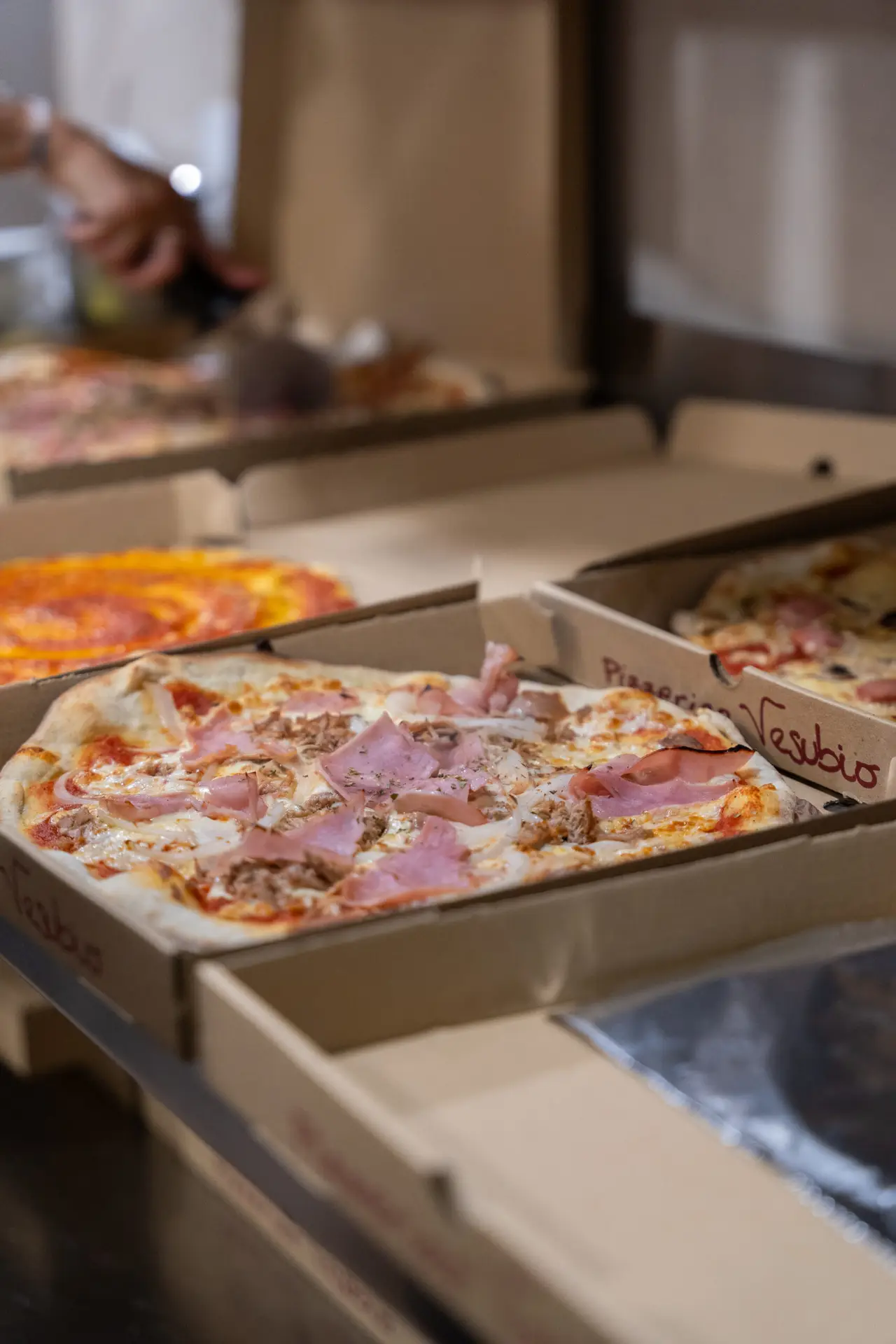 Pizzas artesanales de Pizzería Vesubio en cajas abiertas listas para reparto.